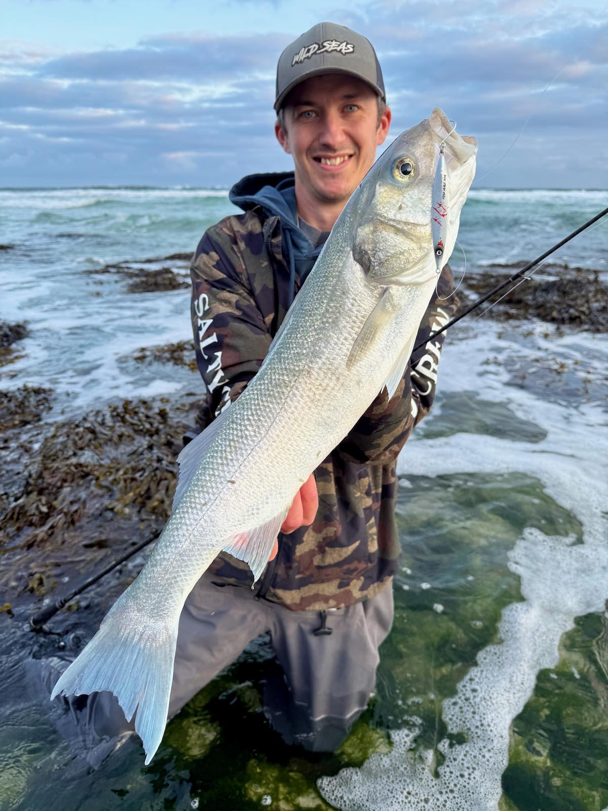 Liam with a nice Bass caught from a surf beach using the Fish Nugz Slayer Cast Jig in Bloody Pearl colour