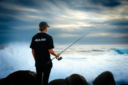 Man fishing wearing a Wild Seas Classic Logo T-Shirt